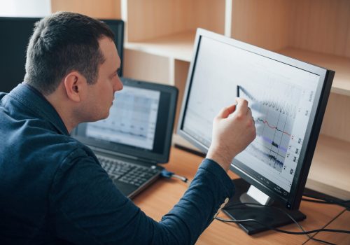 Putting attention for every moment. Polygraph examiner works in the office with his lie detector's equipment.